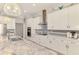 Well-lit kitchen with white cabinets, stainless steel appliances, and a marble countertop island at 6444 Alhambra Ave, North Port, FL 34291