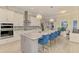 Modern kitchen featuring white cabinets, a large island with seating, and stainless steel appliances at 6444 Alhambra Ave, North Port, FL 34291