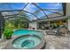 A backyard pool and spa are surrounded by a screened enclosure and patio space at 6444 Alhambra Ave, North Port, FL 34291