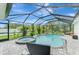 The screened-in pool area boasts a sparkling pool, hot tub, and surrounding greenery at 6444 Alhambra Ave, North Port, FL 34291
