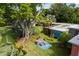 Secluded backyard featuring lush greenery, artistic murals, and a cozy outdoor seating area at 1027 Coral Ridge Dr, Punta Gorda, FL 33950