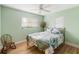 Bedroom with a floral patterned bed, ceiling fan, wood flooring, windows, and a rocking chair at 1027 Coral Ridge Dr, Punta Gorda, FL 33950