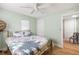 Bedroom with a floral patterned bed, ceiling fan, wood flooring, and access to closet and adjoining room at 1027 Coral Ridge Dr, Punta Gorda, FL 33950