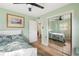 Bedroom with a floral patterned bed, ceiling fan, wood flooring, art and closet with sliding mirror doors at 1027 Coral Ridge Dr, Punta Gorda, FL 33950