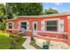 Charming coral-colored home with white trim, decorative shutters and walkway leading to the front door at 1027 Coral Ridge Dr, Punta Gorda, FL 33950