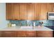 Kitchen with wooden cabinets, stainless steel appliances and a unique backsplash design at 1027 Coral Ridge Dr, Punta Gorda, FL 33950