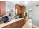 Well-lit kitchen with wooden cabinets, stone countertops, a window and view to the living room at 1027 Coral Ridge Dr, Punta Gorda, FL 33950