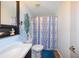 Cozy bathroom featuring a vanity with ample storage, a toilet, and a shower with a decorative curtain at 1115 San Cristobal Ave, Punta Gorda, FL 33983