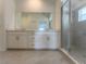 Well-lit bathroom featuring a double vanity, a large mirror, and a glass-enclosed shower for added convenience at 12390 Wellen Golf St # 202, Venice, FL 34293