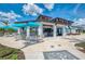 Outdoor seating area at the clubhouse with tables, chairs, and umbrellas for shade at 12390 Wellen Golf St # 202, Venice, FL 34293