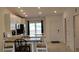 Bright dining area features a modern table set, a view through sliding doors and access to the kitchen and entry at 12390 Wellen Golf St # 202, Venice, FL 34293