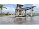 View of the community entrance with gatehouse and manicured landscaping at 12390 Wellen Golf St # 202, Venice, FL 34293