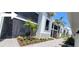 Condominium exterior with a screened in patio with plants and tropical landscaping at 12390 Wellen Golf St # 202, Venice, FL 34293