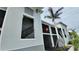 View of the condominium exterior featuring private screened in patios and tropical landscaping at 12390 Wellen Golf St # 202, Venice, FL 34293