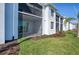 Attractive condominium exterior featuring a screened patio, lush green landscaping, and a well-maintained lawn at 12390 Wellen Golf St # 202, Venice, FL 34293