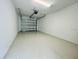 View of a spacious garage with a roll-up door and overhead lighting at 12390 Wellen Golf St # 202, Venice, FL 34293