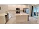 Well-appointed kitchen featuring stainless steel appliances, an island, and access to the outdoor patio at 12390 Wellen Golf St # 202, Venice, FL 34293