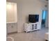 Bright living space with neutral palette, showcasing a built-in display, tv, and access to another bedroom at 12390 Wellen Golf St # 202, Venice, FL 34293