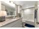 Clean bathroom with granite countertop, white cabinets, and shower-tub combo with glass door at 1250 W Marion Ave # 333, Punta Gorda, FL 33950