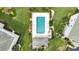 Aerial view of a community pool with ample lounge chairs, greenery, and a small cabana at 1250 W Marion Ave # 333, Punta Gorda, FL 33950