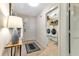 Inviting foyer with tile flooring, console table with decor, and white entry door leading to laundry room at 1250 W Marion Ave # 333, Punta Gorda, FL 33950