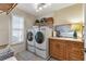 Charming laundry room featuring front-loading washer and dryer, custom cabinets, and an accenting painting over sink at 1250 W Marion Ave # 333, Punta Gorda, FL 33950