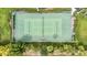 Aerial view of a green tennis court featuring a net and surrounding greenery at 1250 W Marion Ave # 333, Punta Gorda, FL 33950