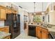 Bright kitchen featuring granite countertops, stainless steel appliances, and custom wood cabinetry at 13139 Preserve Ct, Port Charlotte, FL 33953