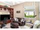 Comfortable living room with dark leather sofa, flat screen TV, built-in shelving, and natural light at 13139 Preserve Ct, Port Charlotte, FL 33953