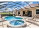 Beautiful screened-in pool and hot tub, surrounded by lounge chairs and lush landscaping at 13139 Preserve Ct, Port Charlotte, FL 33953
