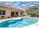 Sparkling pool and spa in screened enclosure with lounge area and mature greenery at 13139 Preserve Ct, Port Charlotte, FL 33953