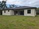 Exterior view of the back of the home showcasing the covered patio and lush backyard at 136 Sequoyah Dr, Port Charlotte, FL 33954