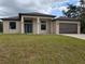 Modern home featuring a neutral color scheme, double door entry, and a two-car garage at 136 Sequoyah Dr, Port Charlotte, FL 33954