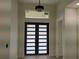 Home interior highlighting the modern front door and elegant overhead lighting fixture at 136 Sequoyah Dr, Port Charlotte, FL 33954