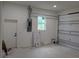 Unfinished garage space with electrical panel, window, and garage door at 136 Sequoyah Dr, Port Charlotte, FL 33954