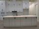Bright kitchen with white cabinets, black hardware, spacious island, and gold pendant lighting at 136 Sequoyah Dr, Port Charlotte, FL 33954