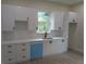 Bright kitchen featuring white cabinets, light countertops, tiled backsplash and stainless steel appliances at 136 Sequoyah Dr, Port Charlotte, FL 33954