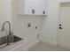 Laundry room featuring modern sink with stainless steel faucet and white cabinets at 136 Sequoyah Dr, Port Charlotte, FL 33954