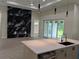 Open concept living room and kitchen with a statement wall, pendant lights, and glass sliding doors at 136 Sequoyah Dr, Port Charlotte, FL 33954