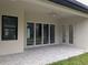 Covered patio featuring ceiling fan, glass sliding doors, and tile pavers at 136 Sequoyah Dr, Port Charlotte, FL 33954