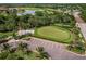 Golf course aerial showcases a putting green framed by trees and parking area at 14141 Heritage Landing Blvd # 921, Punta Gorda, FL 33955