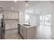 Bright, modern kitchen with white cabinets, stainless steel appliances, and a large island overlooking the living area at 14141 Heritage Landing Blvd # 921, Punta Gorda, FL 33955
