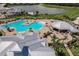 Aerial view of a community pool area with a large pool, jacuzzi, clubhouse, and lake in the background at 14141 Heritage Landing Blvd # 921, Punta Gorda, FL 33955
