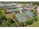 Aerial view featuring multiple tennis and pickleball courts with pristine landscaping and a nearby community center in a beautiful area at 14141 Heritage Landing Blvd # 921, Punta Gorda, FL 33955