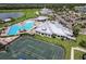 Aerial view of a community tennis courts and a resort-style pool, with clubhouse and manicured landscaping in an upscale neighborhood at 14141 Heritage Landing Blvd # 921, Punta Gorda, FL 33955