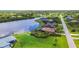 Waterfront home featuring lush landscaping, screened-in pool, and private dock for ultimate outdoor enjoyment at 170 Antilla Dr, Rotonda West, FL 33947