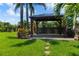 Charming backyard featuring gazebo, lush landscaping, stepping stones and tropical foliage for a serene escape at 170 Antilla Dr, Rotonda West, FL 33947