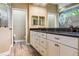 Bathroom featuring double vanity with dark countertop and decorative shower glass at 170 Antilla Dr, Rotonda West, FL 33947