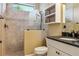 Bathroom featuring tiled walk-in shower, vanity with dark counters, and built-in shelving at 170 Antilla Dr, Rotonda West, FL 33947