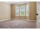 Spacious bedroom featuring a bay window with plantation shutters and neutral colored carpet at 170 Antilla Dr, Rotonda West, FL 33947